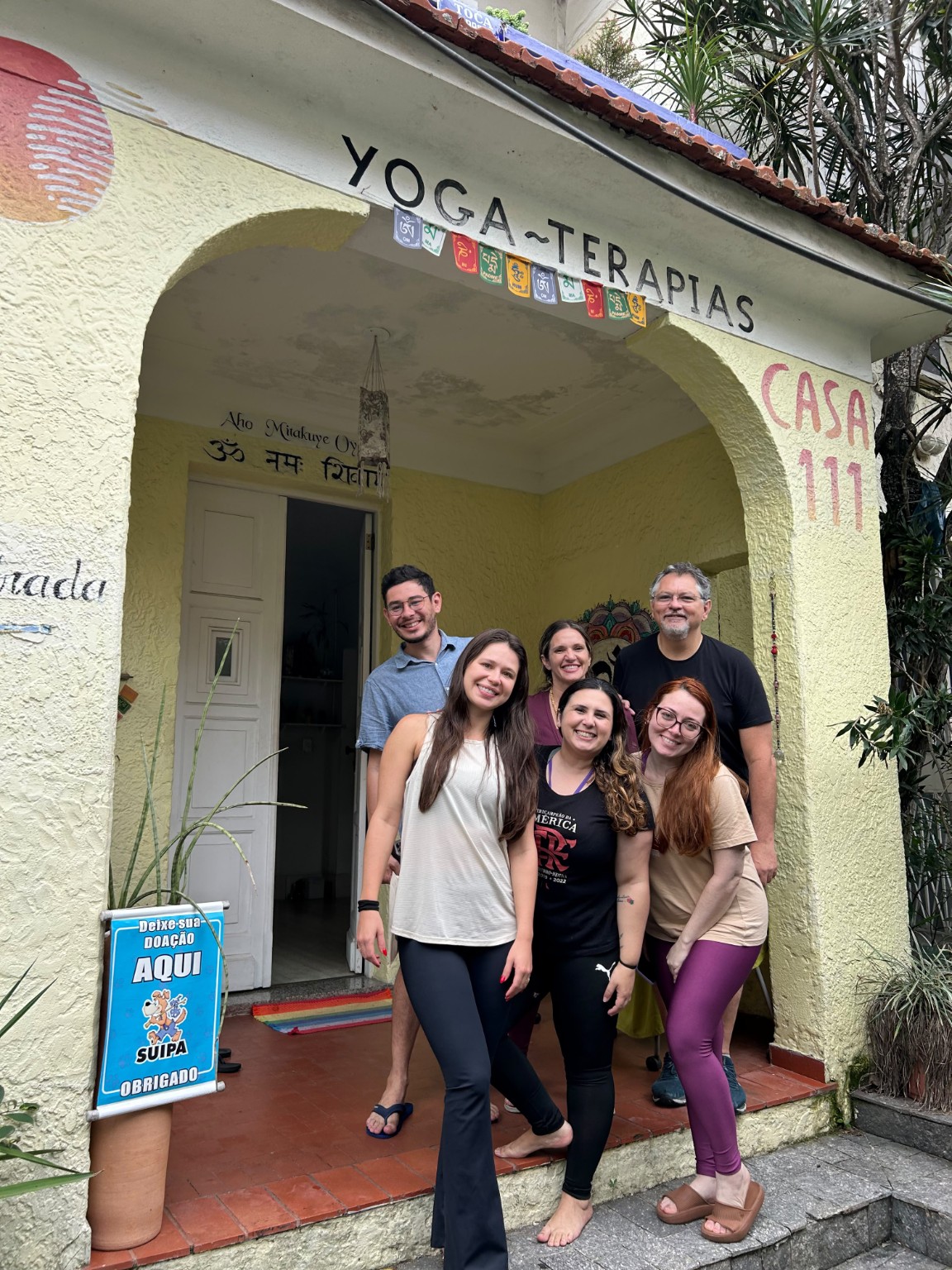 Participantes reunidos diante da fachada da Casa 111