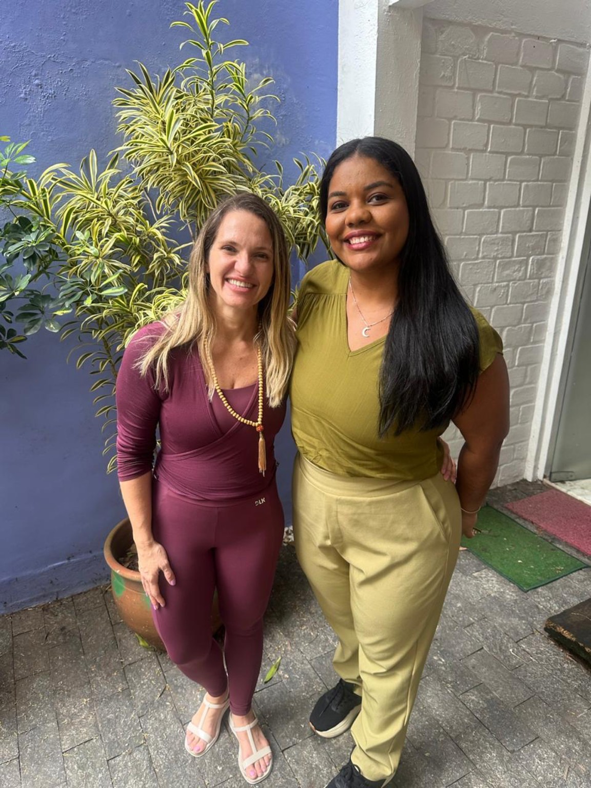 Duas participantes sorrindo no jardim da Casa 111