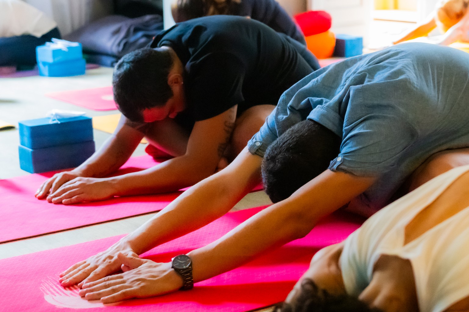 Participantes em flexão à frente durante a prática de Yoga na Casa 111