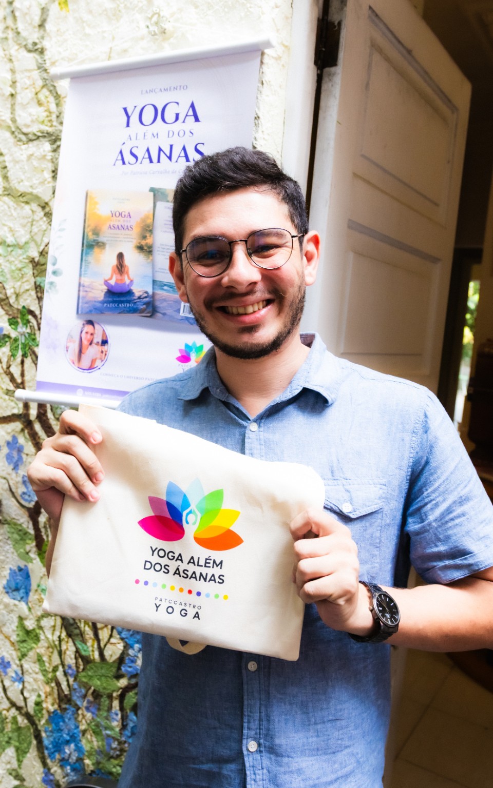 Participante sorrindo com um exemplar de Yoga Além dos Ásanas