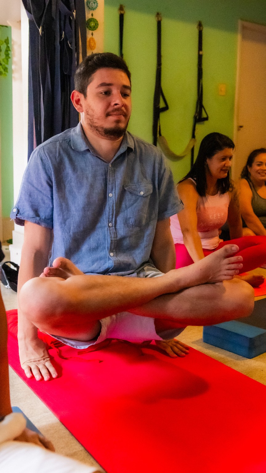 Participante de camiseta azul sentado com as pernas cruzadas